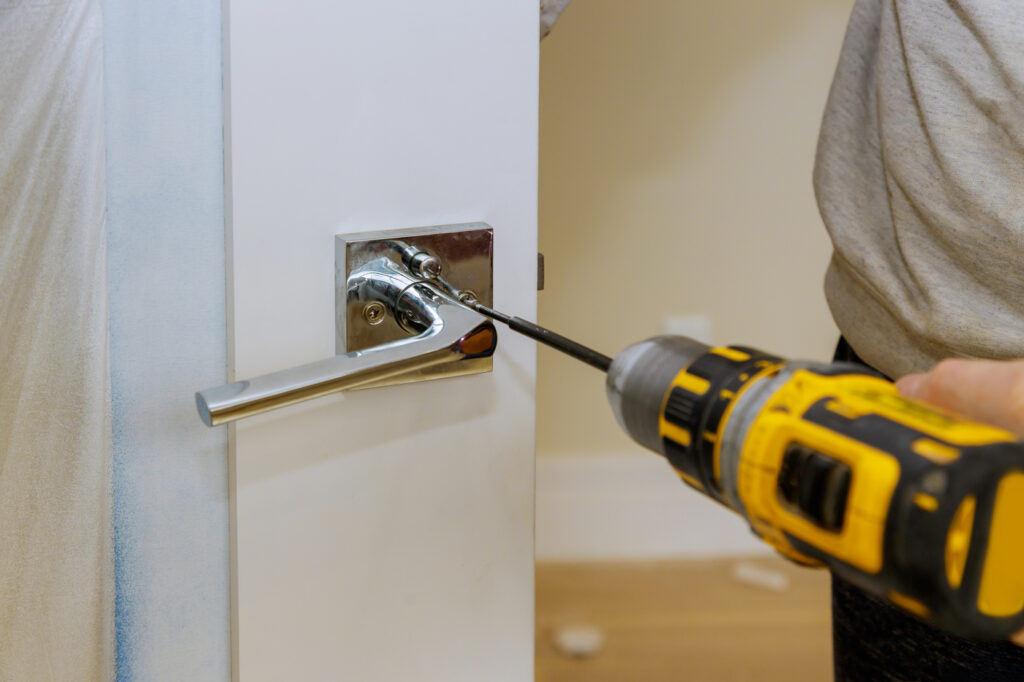 Locksmith installing modern door handle lock for home security