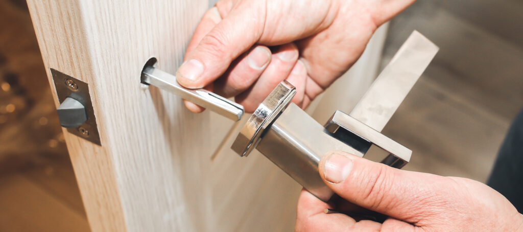 Emergency locksmith installing door handle lock