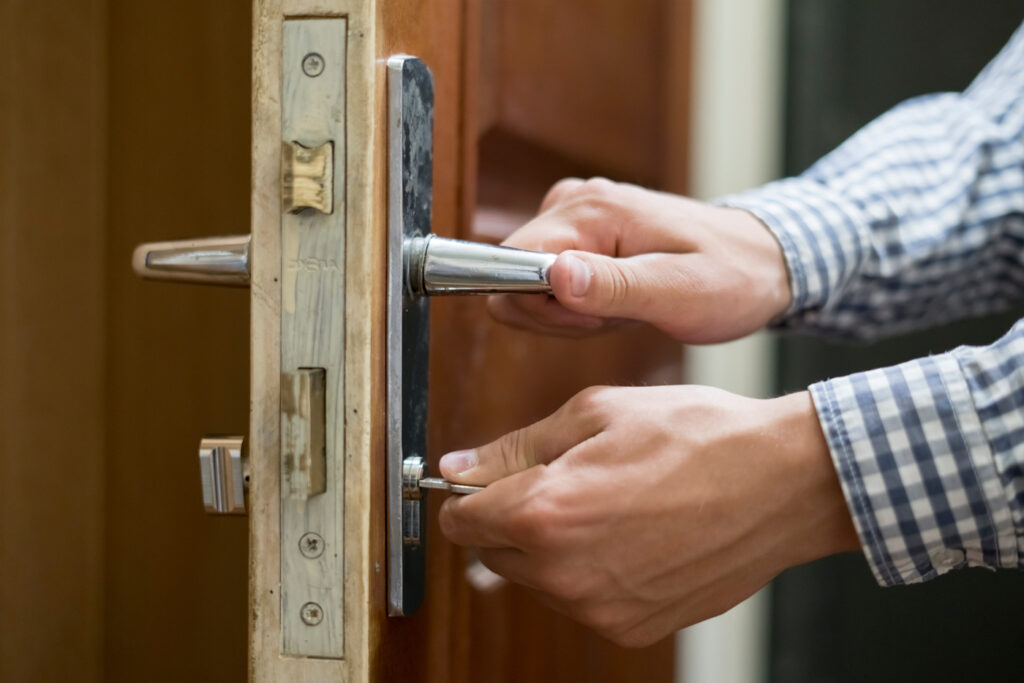 Locksmith unlocking traditional lock on front door